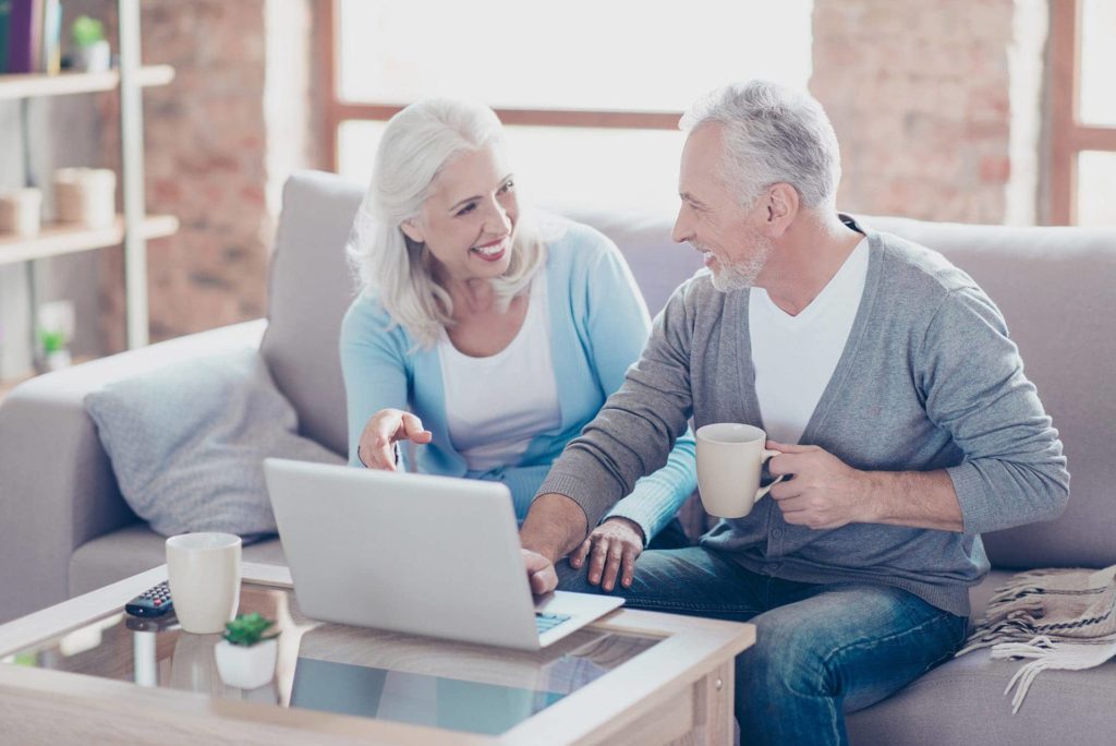 An older woman and man researching Medicare plans on a laptop