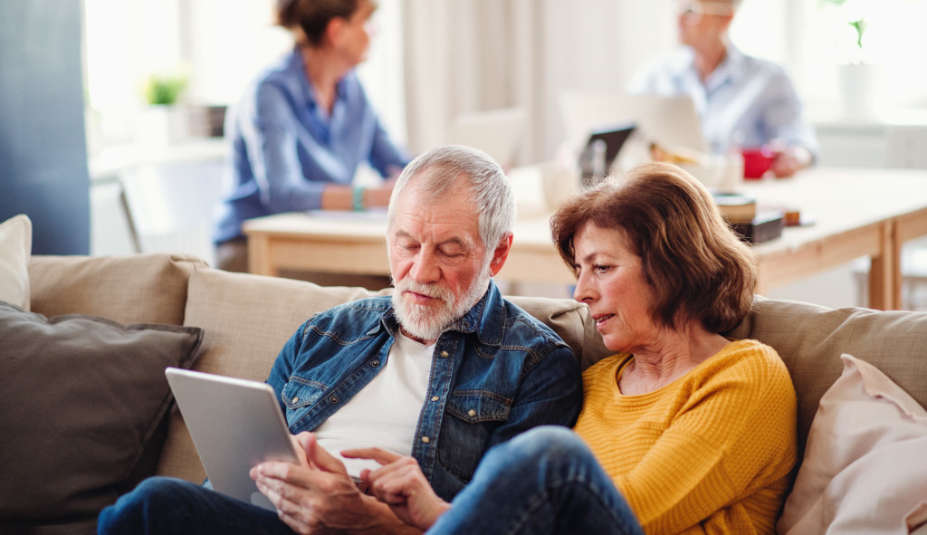 Senior couple on sofa using a tablet