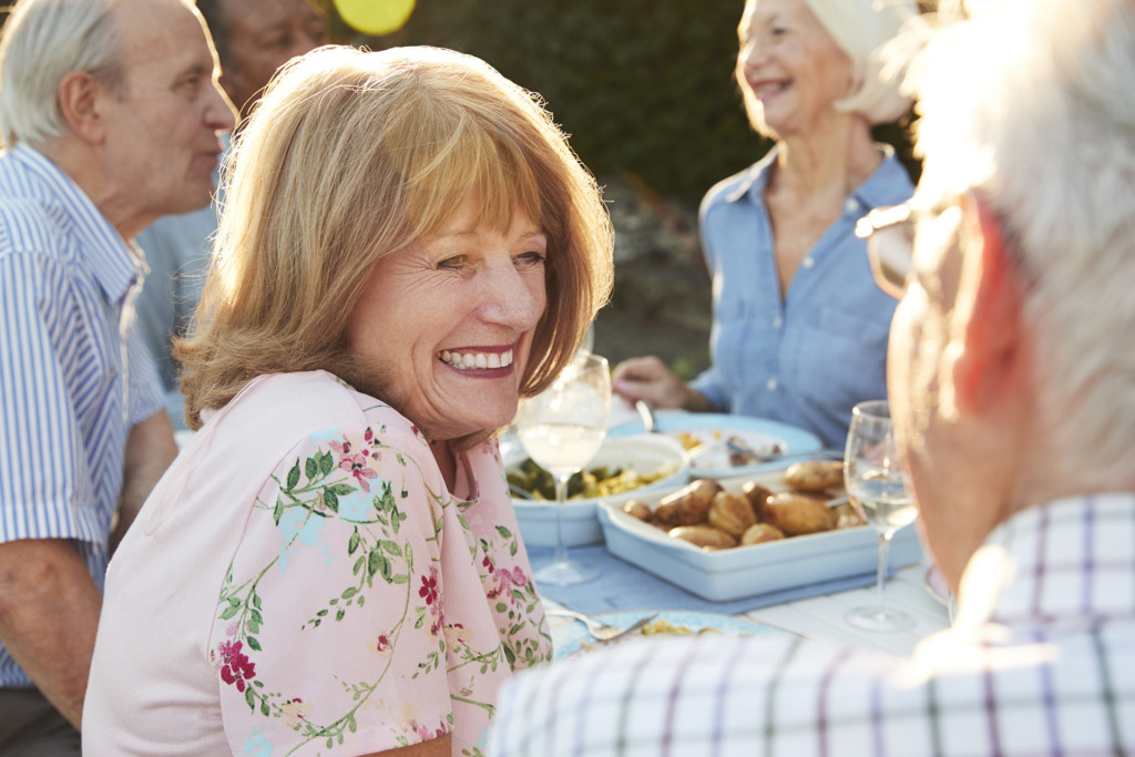 Group Of Senior Friends Enjoying Outdoor Dinner Party At Home