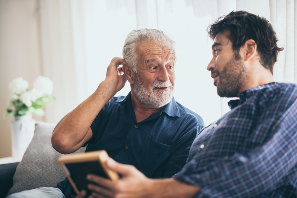 Father and son sitting on sofa talking