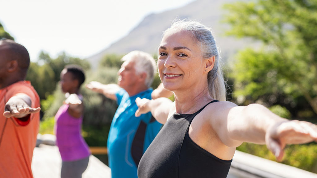 senior woman excising with group outside