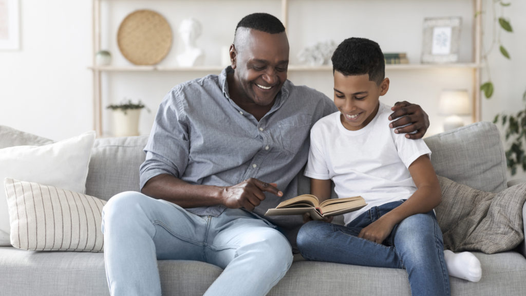 man looking at book with son