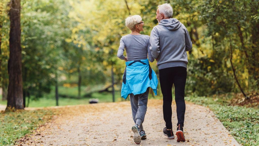 senior couple walking in park