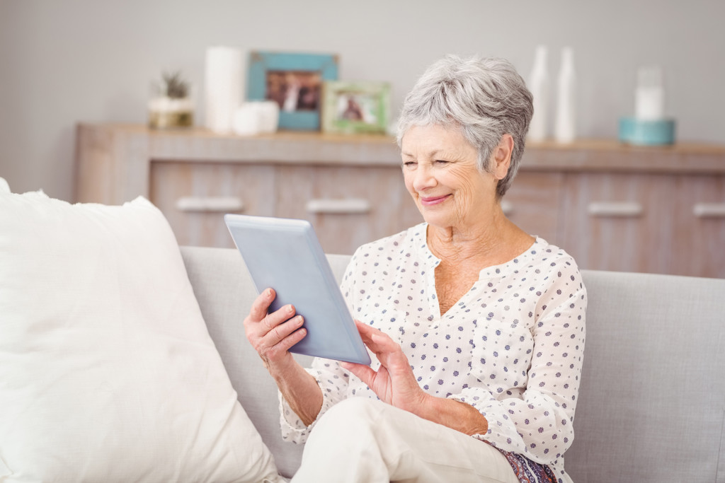 Senior woman on sofa using digital tablet