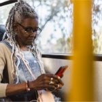 Older adult woman on bus using smartphone