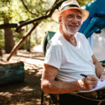 smiling older man in hat driving convertible