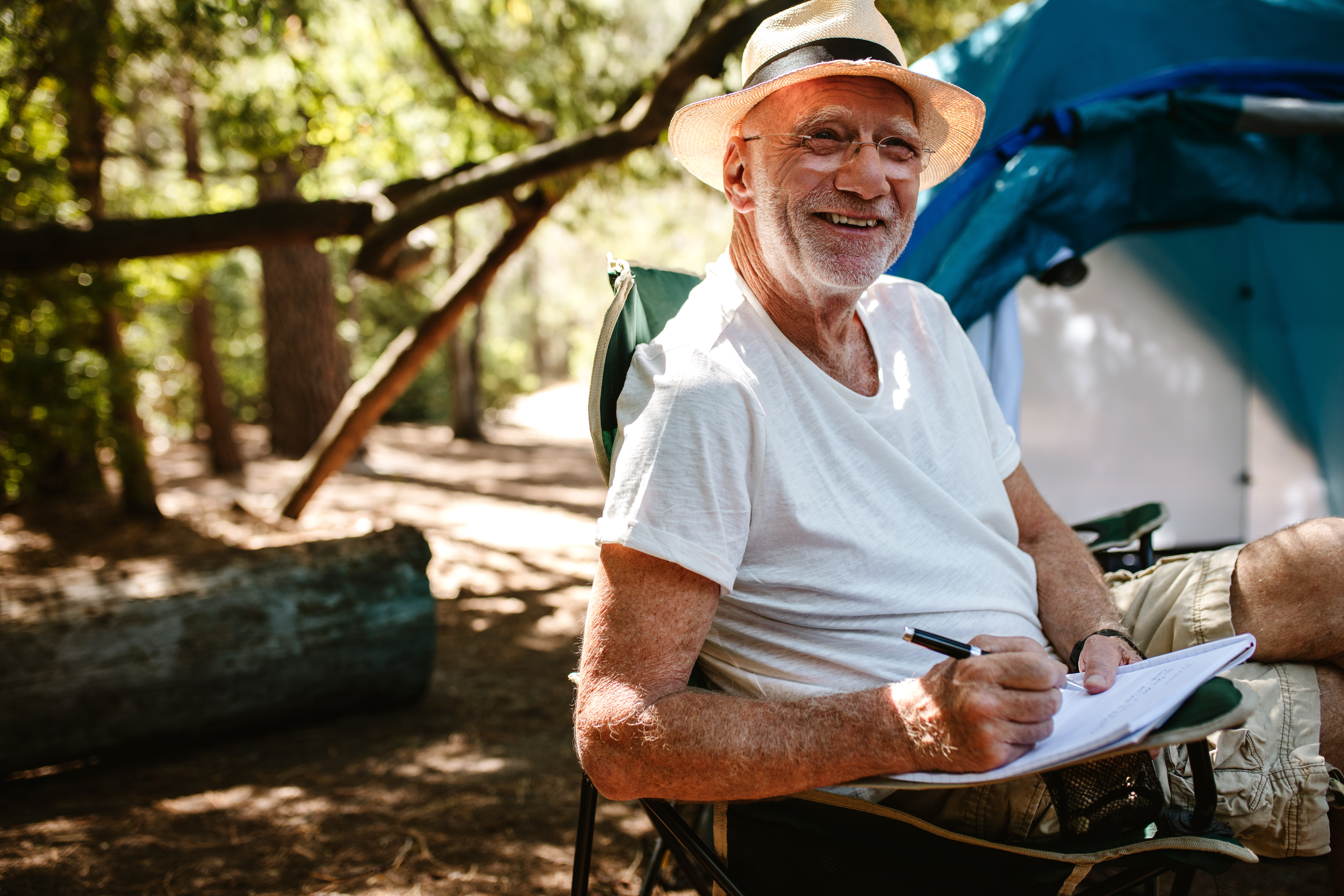 smiling older man in hat driving convertible